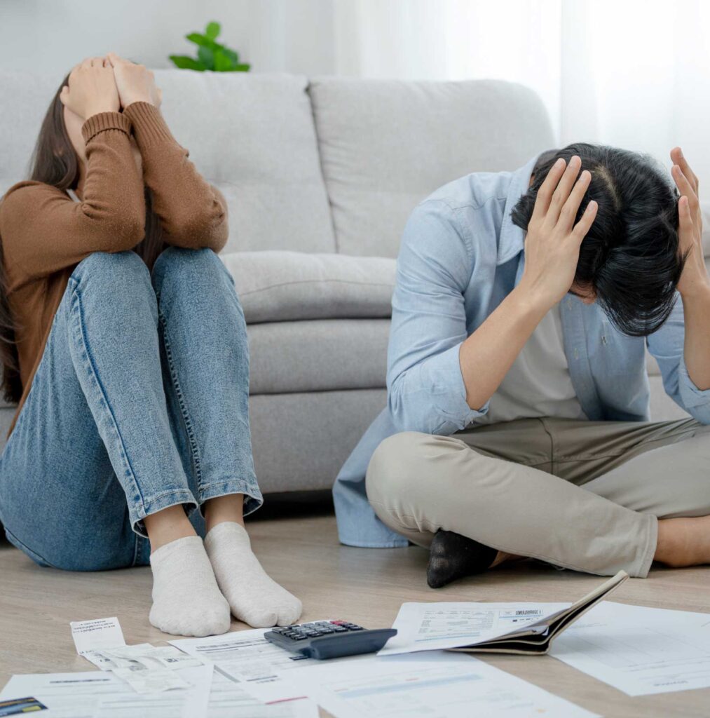 Foto de um casal desesperado ao olhar para as finanças