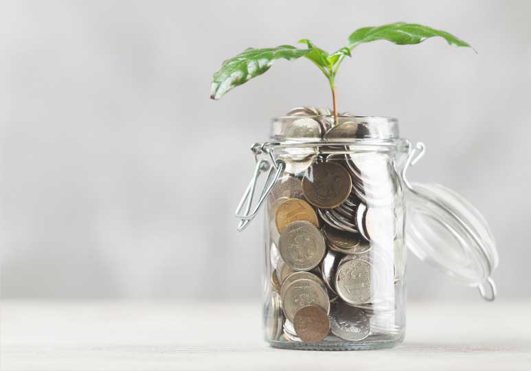 imagem de frasco de vidro com moedas de onde nasce uma pequena planta